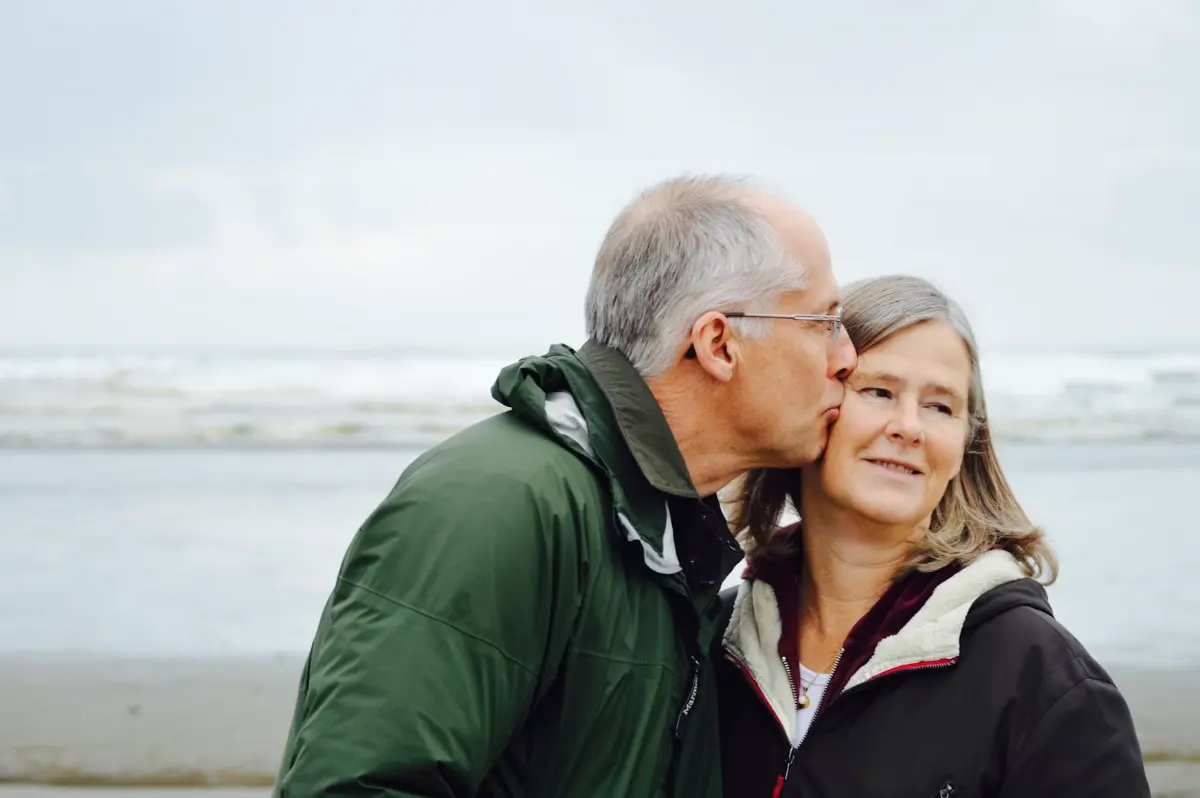 Casal de idosos abraçados ao ar livre, em um dia comum